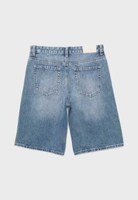 Pohled zezadu na modré džínové šortky střední délky s dvěma zadními kapsami a poutky na pásek.