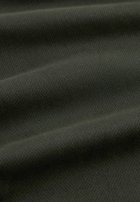Tissu texturé vert olive foncé, présentant une surface lisse avec un motif subtil de petits points en relief, exposé en couches pliées.