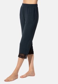 Dunkelblaue Caprihosen aus weichem Material mit einem elastischen Taillenbund und schwarzem Spitzenbesatz am Saum. Mit Falten für zusätzlichen Stil.