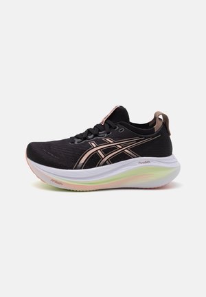 Zapatilla de running negra con logotipo ASICS en oro rosa metálico, suela blanca acolchada con detalles verdes y rosas, y lengüeta de agarre en el talón.