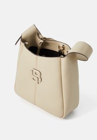 Borsa a secchiello in pelle beige con finitura testurizzata, dotata di una cerniera in tonalità oro, dettaglio con logo e una forma morbida e strutturata.