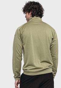 Olivgrüner Fleece-Pullover mit hohem Kragen, langen Ärmeln und glatter Textur, mit einer taillierten Silhouette und geripptem Saum.