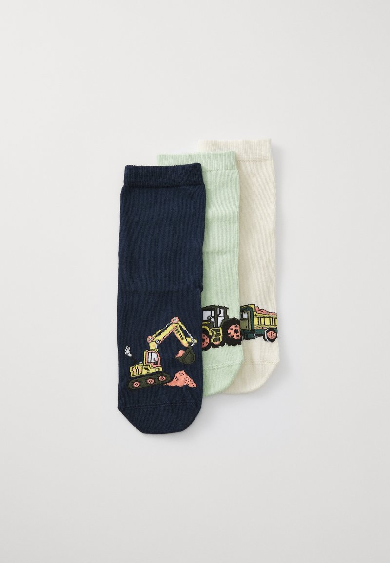 Trois paires de chaussettes pour enfants : bleu foncé avec un camion de chantier jaune, vert clair avec un tracteur, et crème avec un véhicule de construction, en coton.