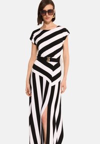Maxi sukienka w czarno-białe ukośne paski, z krótkimi rękawami, dopasowaną talią z złotym paskiem i rozcięciem na wysokości uda z przodu.