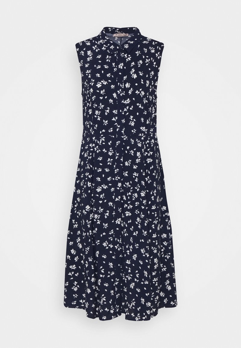 Navy bloemenprint jurk, mouwloos met een kraag, voorzien van witte bloemen, geplooide rok en knoopsluiting aan de voorkant.