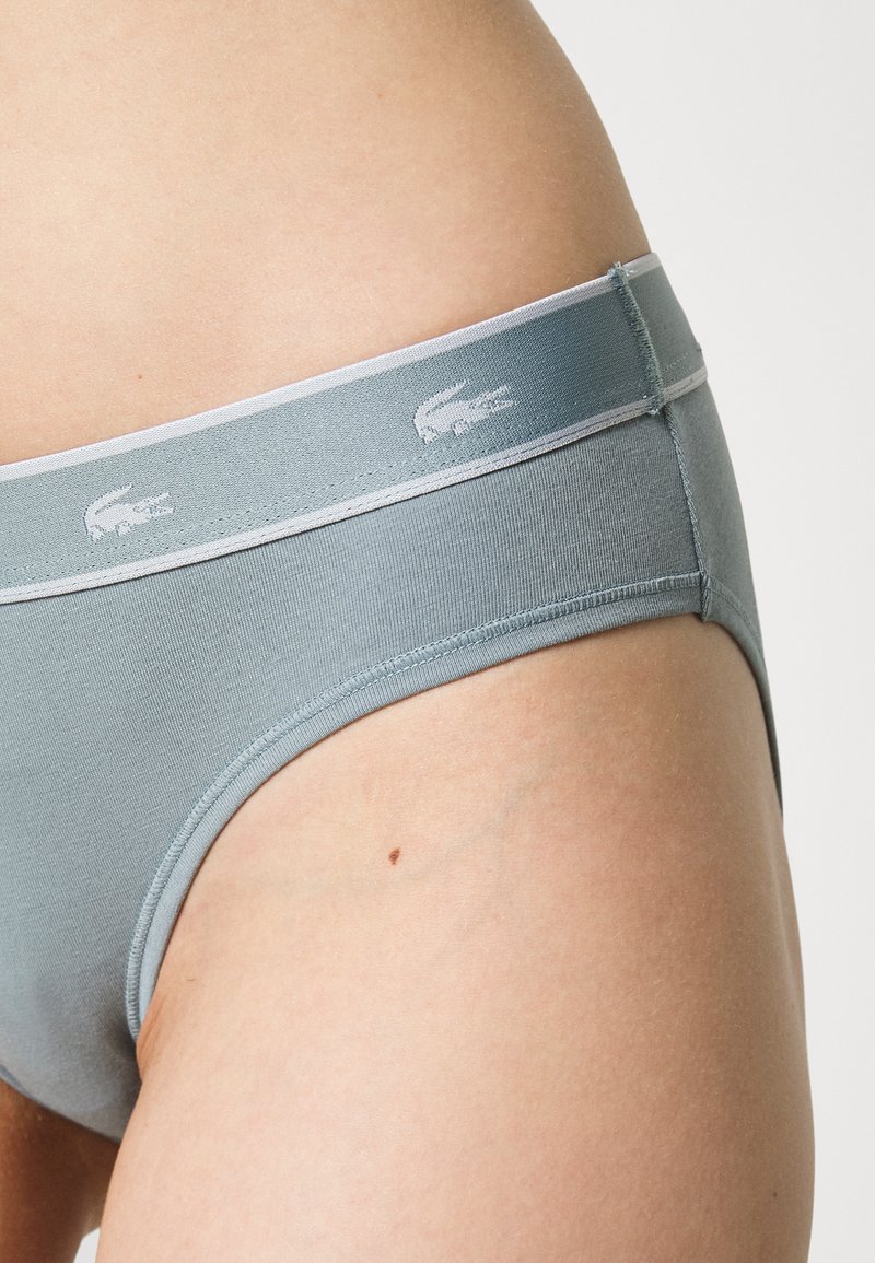 Jasnoszare majtki wykonane z gładkiego materiału, z elastycznym pasem z subtelnym logo i krojem hipster.