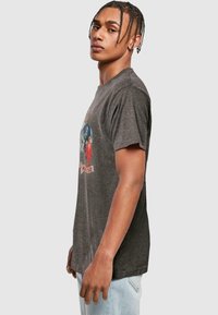 Graues Baumwoll-T-Shirt mit Rundhalsausschnitt und kurzen Ärmeln, das einen bunten Grafikdruck auf der Vorderseite zeigt, mit Figuren und Text.