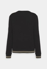 Sudadera negra de manga larga, con cuello redondo y puños acanalados, adornada con dos franjas doradas en el dobladillo y los extremos de las mangas. Textura suave.