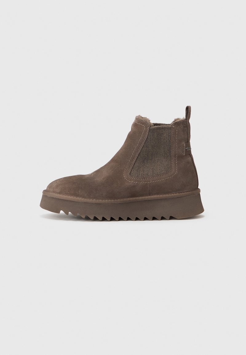 Botte Chelsea en daim marron avec panneaux latéraux élastiques, languette au talon, doublure en peau retournée et semelle en caoutchouc épaisse à rainures.