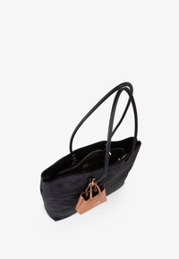 Borsa tote in suede nero con doppie cinghie lunghe, dotata di una borsa più piccola attaccata di colore marrone. Il design include un lettering in rilievo discreto.
