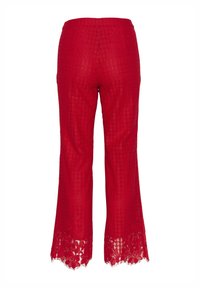 Pantalon court en dentelle rouge avec un motif floral et des ourlets festonnés, vu de dos sur un fond blanc.