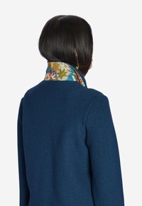 Dark blue coat with a textured fabric. Inner collar features a colorful floral pattern on a light blue background. Back view shown.