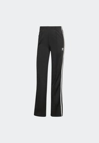 Pantalones deportivos negros de corte relajado, confeccionados en tejido suave, con rayas laterales blancas y una cinturilla elástica.