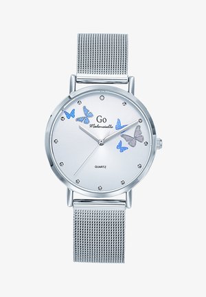 Montre en quartz argentée avec un cadran blanc texturé, des accents de papillon bleus, des marqueurs en cristal et un bracelet en maille argentée.