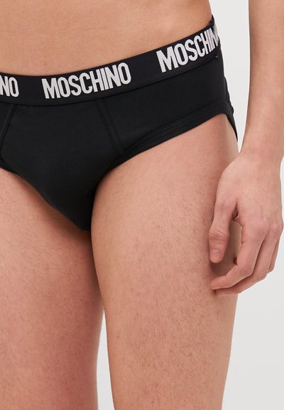 Caleçons noirs en coton avec un logo « Moschino » blanc sur la ceinture élastique, offrant un ajustement serré et une texture lisse.