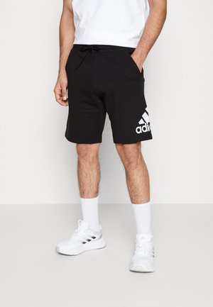 Black cotton athletic shorts with an elastic waistband and drawstring; features a large white Adidas logo printed on the left side.