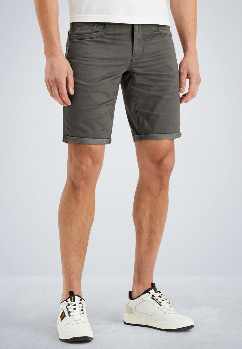 Gray denim shorts with a slim fit, rolled hem, and front pockets. Paired with white sneakers featuring black accents and laces.
