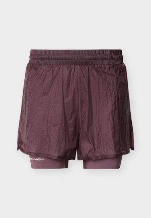 Topeltkihilised tumelilla spordipüksid, millel on elastne vöökoht ja tihedalt istuv sisekiht, mis ulatub alla lahtise väliskihi.