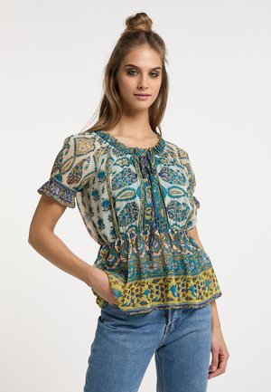 Blomstret peplum-bluse i let stof. Har puffærmer, flæset halsudskæring og et multifarvet design med grønne, blå og gule accenter.