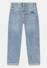 Jasnoniebieskie dżinsy z dwiema tylnymi kieszeniami, pomarańczowymi szwami, zrolowanymi mankietami i małą metką Calvin Klein Jeans na prawej kieszeni.