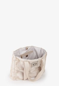 Sac fourre-tout en toile beige avec un motif texturé, deux poignées supérieures et une poche intérieure zippée. Doublé d'un tissu léger et lisse.