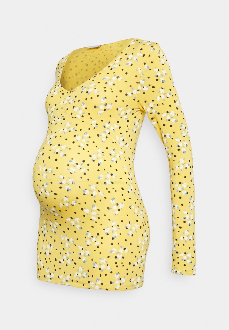 Blusa de maternidade amarela de mangas longas com decote em V, estampa floral espalhada e bolinhas pretas, com um design ajustado e elástico.