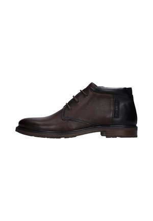 Stivaletto alla caviglia in pelle marrone scuro con sezione tallone nera, tre occhielli per i lacci e tacco basso impilato.