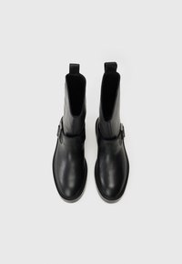 Μαύρες δερμάτινες μπότες αστραγάλου με λεία υφή, στρογγυλή μύτη και λεπτομέρεια με αγκράφα στο πλάι. Σχεδιασμένες με κατακόρυφες ανοίγματα στην κορυφή για εύκολη εφαρμογή.