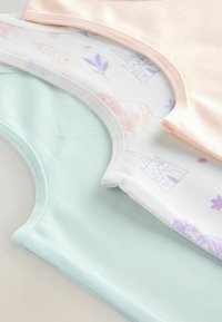 Drei Tanktops in Mintgrün, Weiß mit floralem Muster und sanftem Pfirsich; aus Baumwollstoff, mit runden Ausschnitten und glatter Textur.