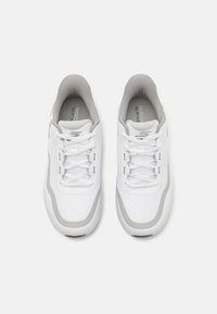 Baskets de sport blanches avec des accents gris, dotées d'une tige en maille texturée, d'un embout rond et de lacets plats. Conception légère pour un confort optimal.
