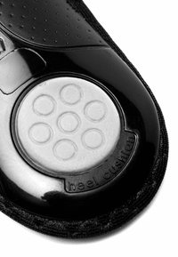 Black shoe insole with a textured surface, featuring a circular gray heel cushion with six raised circles and a "heel cushion" label.
