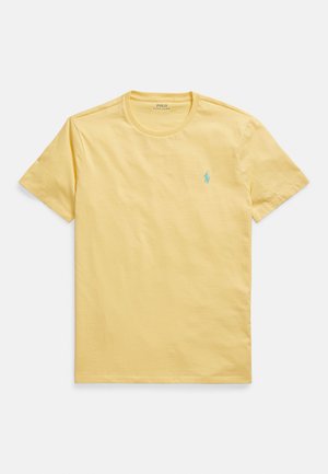 Geltonas medvilninis marškinėlis su apvalia iškirpte, trumpomis rankovėmis ir mažu turkio spalvos polo logotipu kairėje krūtinės pusėje. Lygios tekstūros.