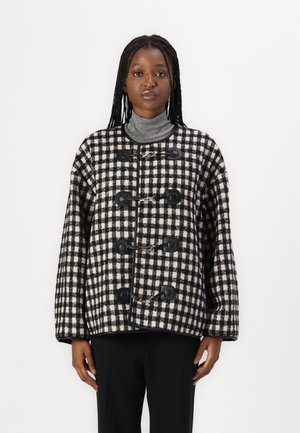 Schwarz-weiß karierte Wollmischung Jacke mit Knebelverschlüssen, weiten Ärmeln und einem kastigen Schnitt, kombiniert mit einem grauen Rollkragenoberteil.