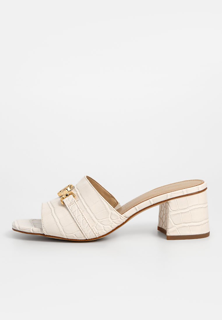Des sandales à talons couleur blanc cassé avec texture crocodile, dotées de deux brides accentuées de garnitures dorées et d'une ouverture carrée à l'avant. Design de talon carré massif.