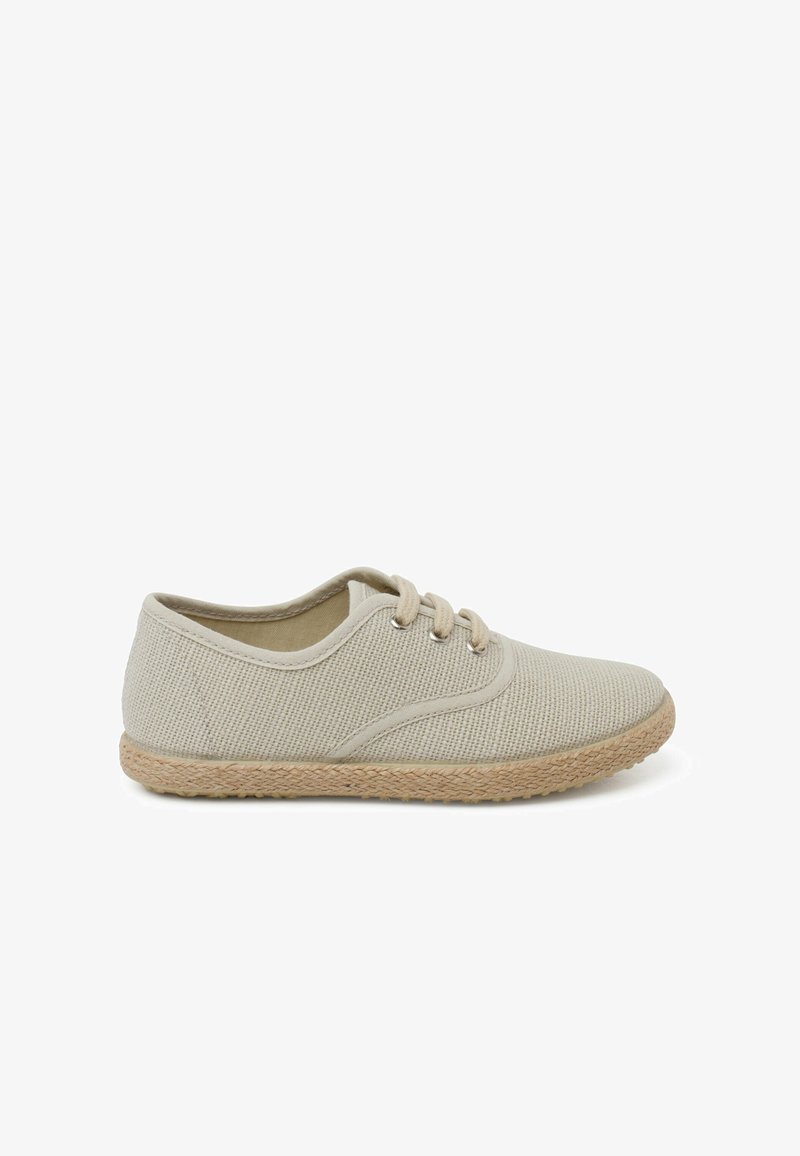 Basket en toile beige avec une surface texturée, une forme arrondie, des lacets en coton et une semelle en jute tissé, conçues pour un usage décontracté.