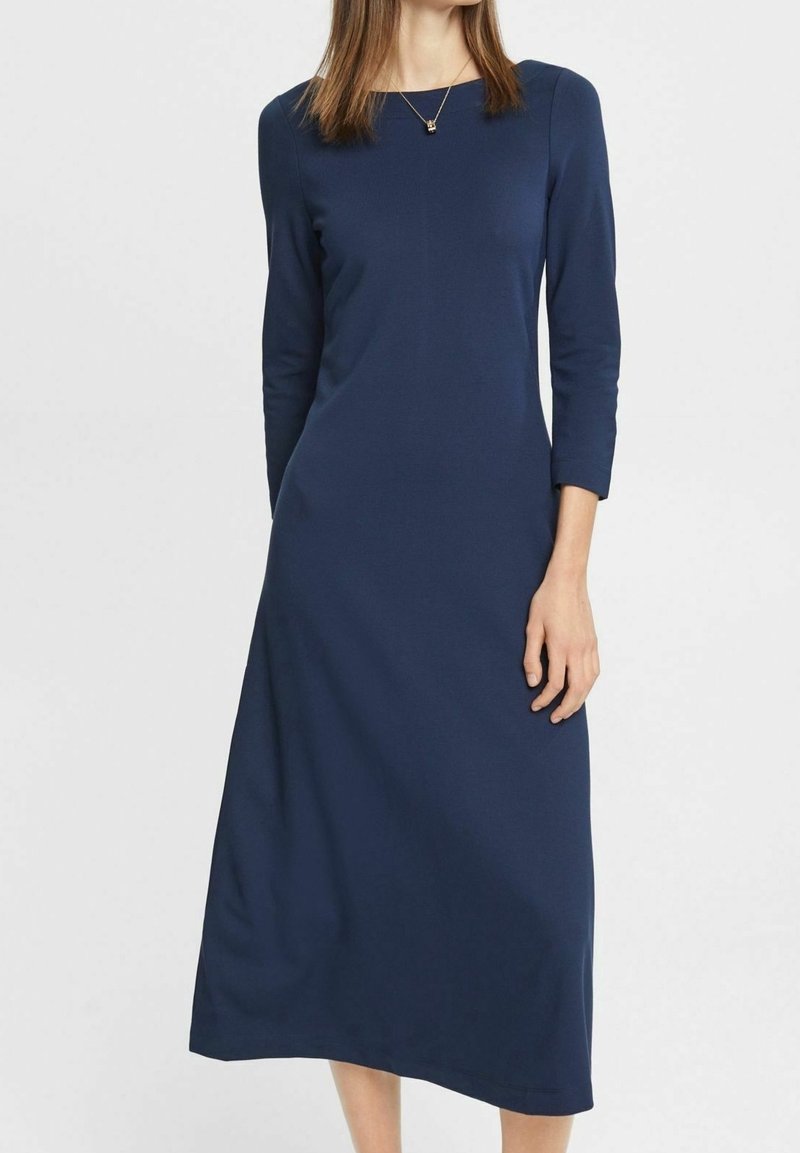 Robe bleu marine à manches longues avec un col arrondi, une texture lisse et une silhouette fluide, s'étendant jusqu'à mi-mollet.