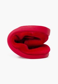 Pantof roșu cu un exterior neted și un interior moale, pufoș. Profil scăzut și formă curbată, evidențiind un design minimalist și o culoare vibrantă.