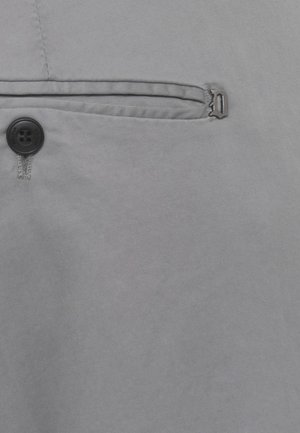 Tessuto grigio con un bottone nero e una tasca con filetto orizzontale stretto dotata di una piccola cerniera metallica.