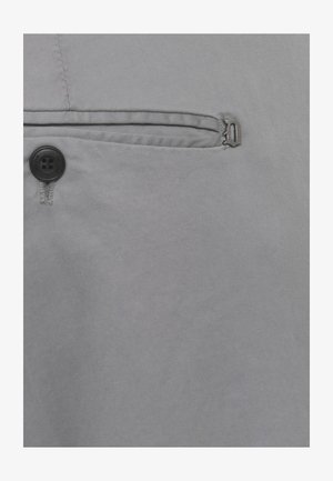 Tessuto grigio con un bottone nero e una tasca con filetto orizzontale stretto dotata di una piccola cerniera metallica.