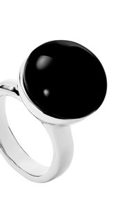 Anillo de plata con una gran piedra ovalada negra. La banda es suave y elegante, complementando el acabado brillante de la piedra.