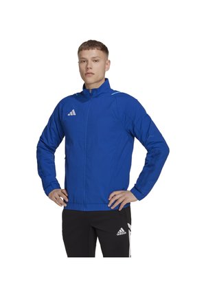 Veste de sport bleue en tissu léger, avec col montant, fermeture éclair et accents de logo blanc sur la poitrine et les manches.