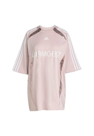Różowa, oversize'owa bluzka sportowa Adidas z białym napisem "TEAMGEIST", cekinowymi akcentami po bokach oraz trzema białymi paskami na rękawach.