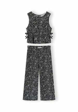 Czarny, bezrękawnik z krótkim topem z wiązaniami po bokach oraz dopasowane szerokie spodnie z drobnym białym kwiatowym wzorem.