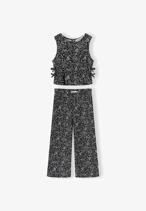 Haut court noir sans manches avec liens sur les côtés et pantalon large assorti, tous deux ornés d'un petit motif floral blanc.