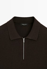 Braun gestricktes Polohemd mit einem gerippten Kragen und einem silbernen Metallreißverschluss, versehen mit einem Etikett, das "Massimo Dutti" liest.