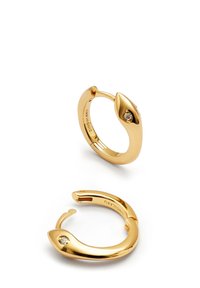 Pendientes de aro en tono dorado con un diseño suave y curvado, y un pequeño acento de gema clara, que cuentan con un mecanismo de cierre tipo gancho.