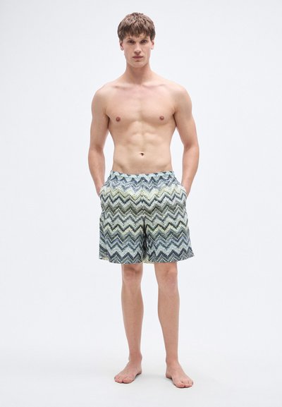 Ανδρικά μαγιό σορτς με ζιγκ ζαγκ σχέδιο σε πράσινο, μπλε και μαύρο. Κατασκευασμένα από ελαφρύ ύφασμα, διαθέτουν ελαστική μέση και τσέπες.