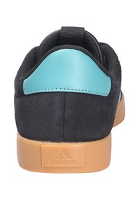 Čierne semišové tenisky s tyrkysovým koženým akcentom, s textúrovaným látkovým zvrškom a gumovou podrážkou. Na zadnej strane je vyrazené logo.