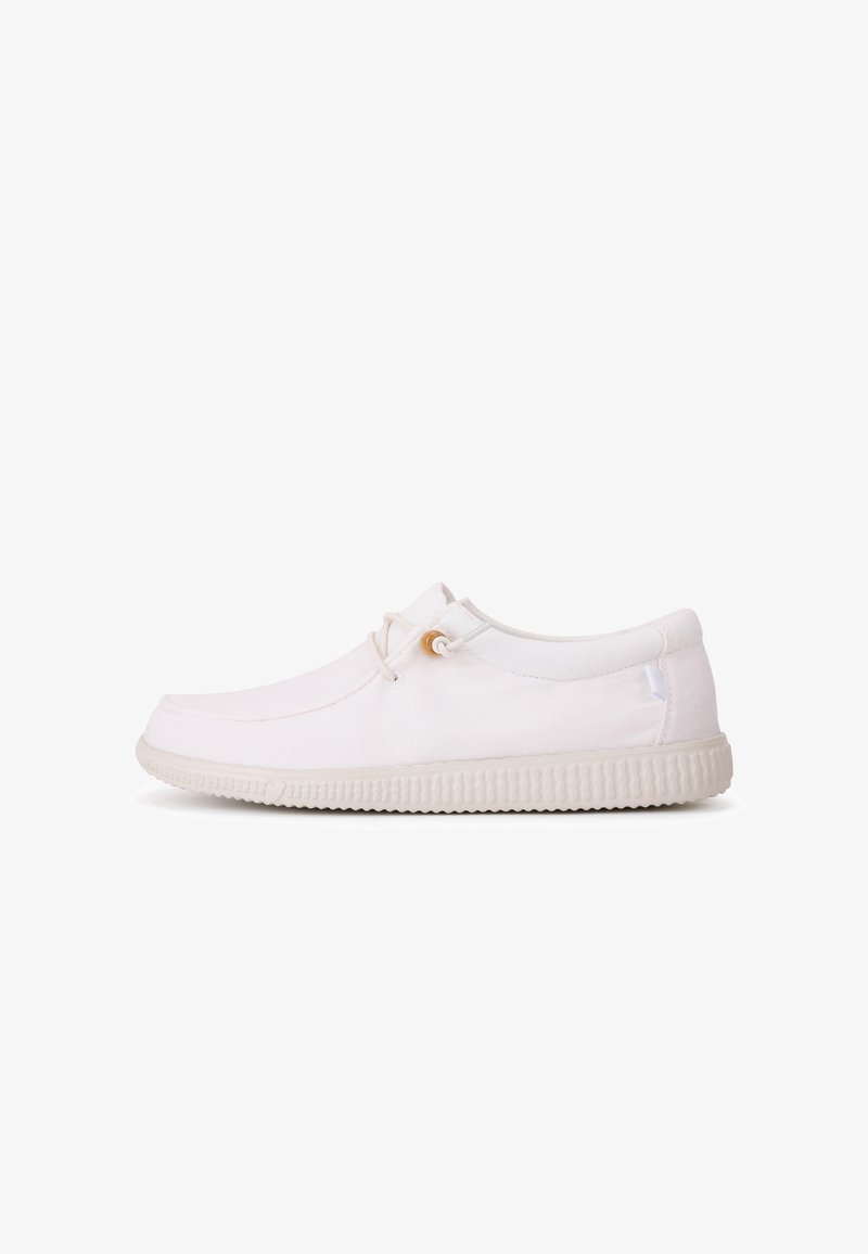 White canvas shoes with a rounded toe, simple design, elastic laces, and textured rubber sole. Side stitching and minimal accents.