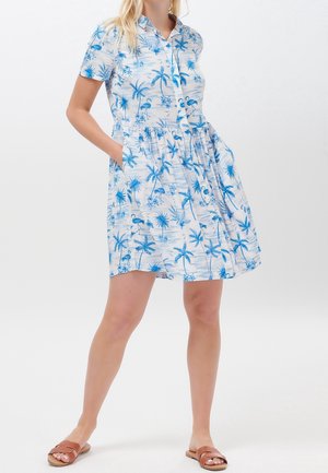 Short-sleeve dress in a light blue and white pattern featuring palm trees and flamingos. Elastic waist with side pockets. Button-down front.
